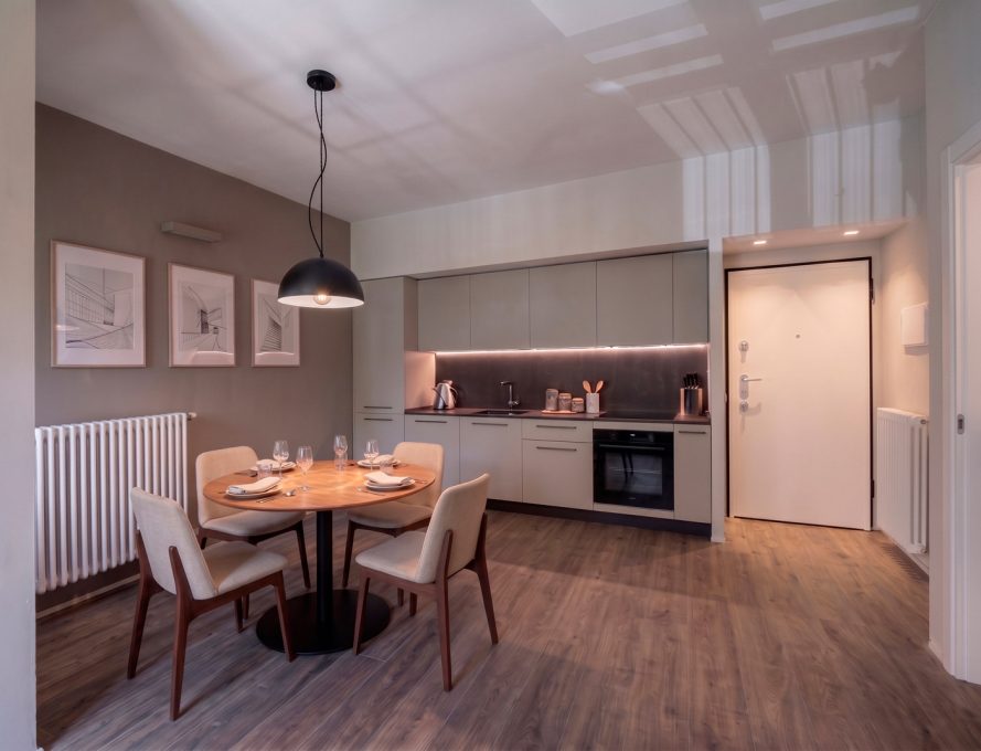Zona giorno contemporanea con cucina lineare e tavolo da pranzo rotondo